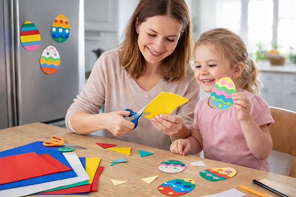 Anya és gyermeke húsvéti díszeket készítenek