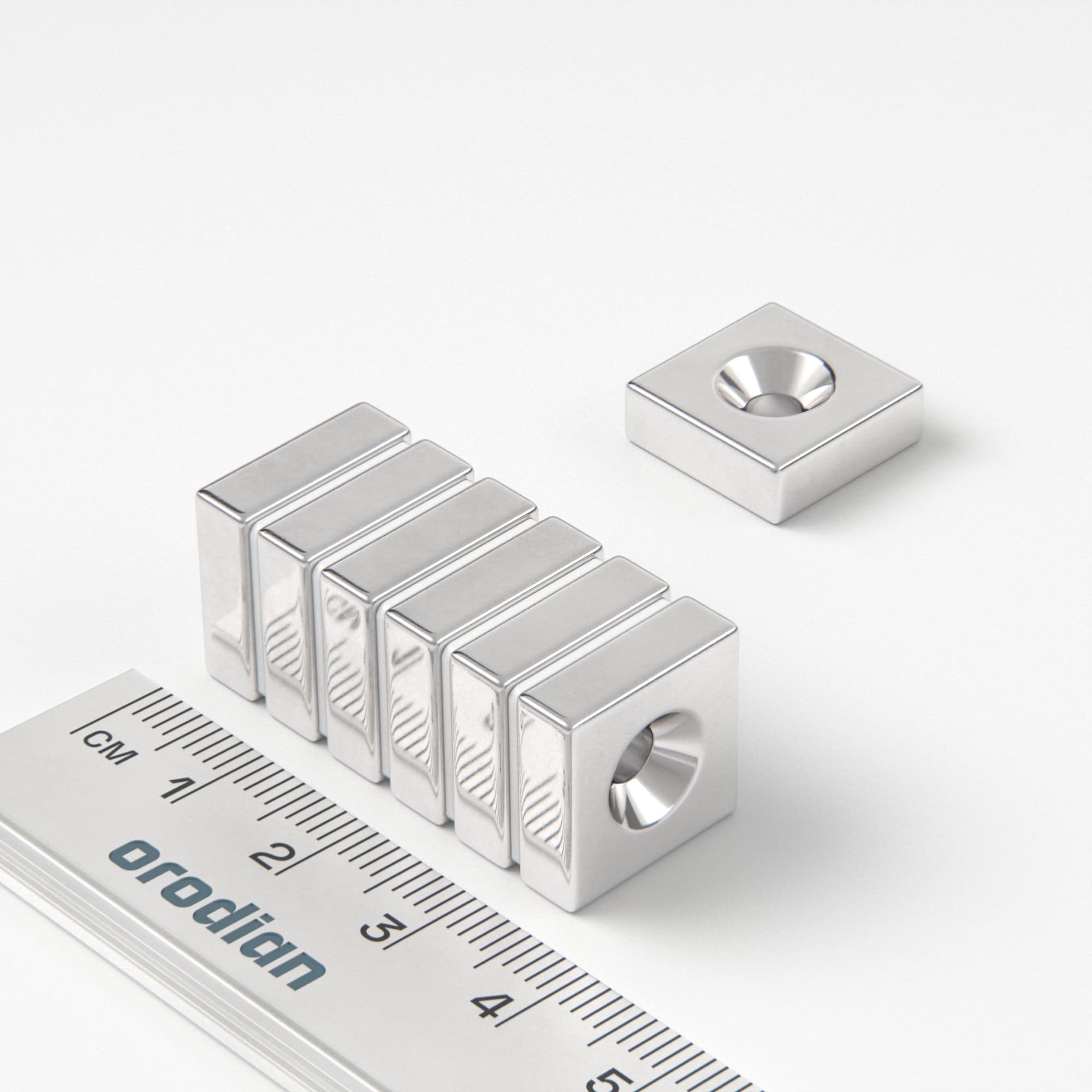 Neodímium mágnes téglatest 15×15×5 mm lyukkal M4 (déli pólus a mélyedés oldalán) - N38