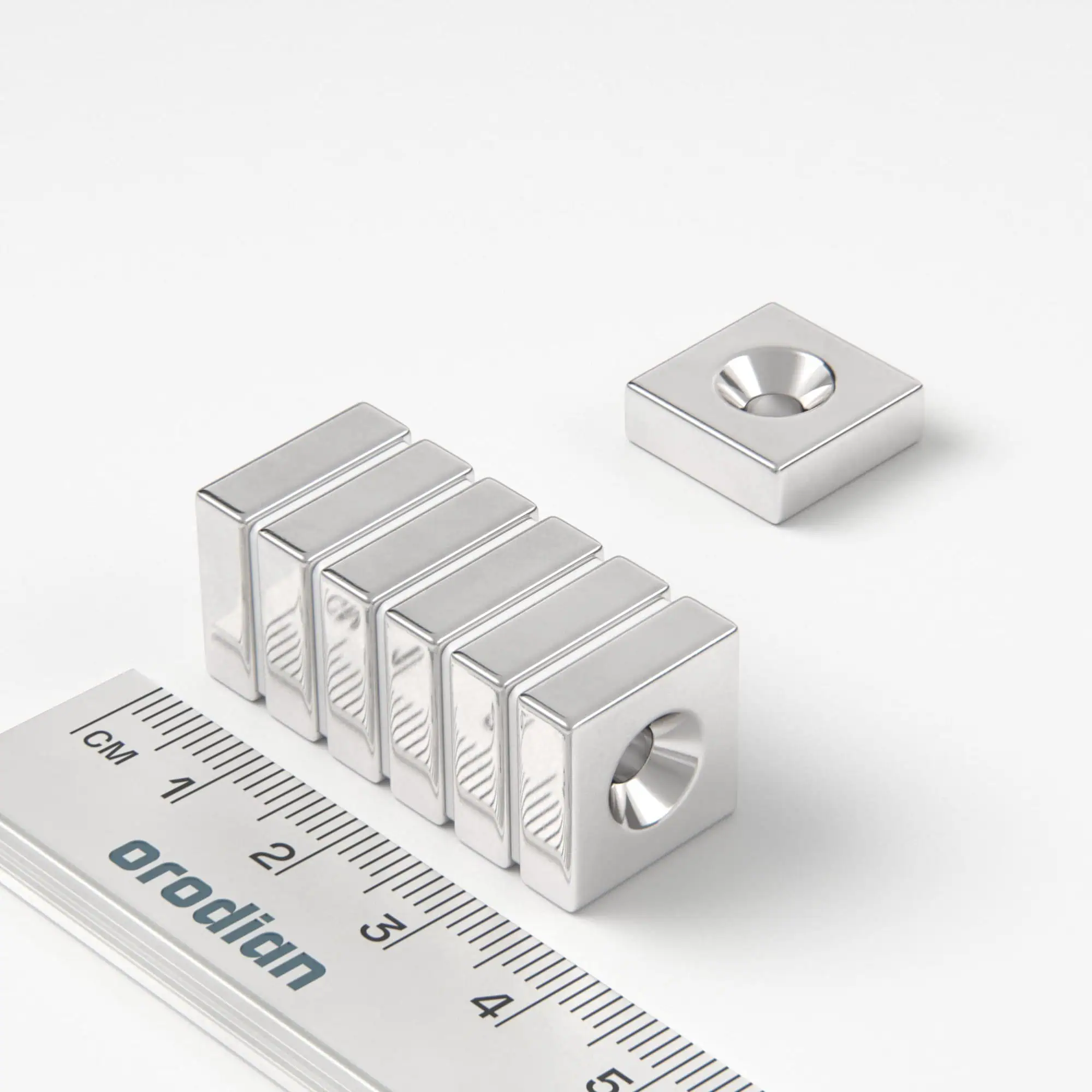 Neodímium mágnes téglatest 15×15×5 mm lyukkal M4 (északi pólus a mélyedés oldalán) - N38