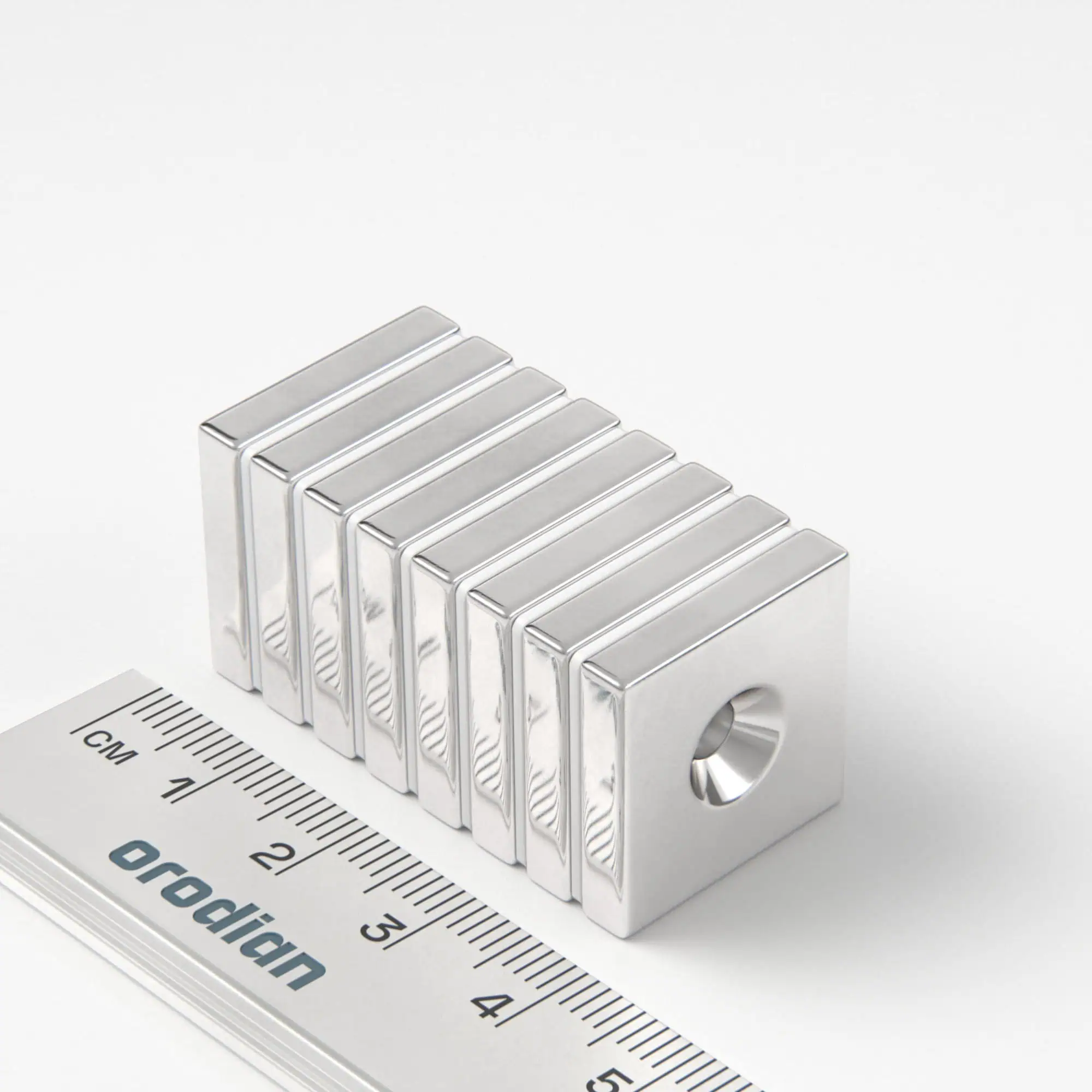 Neodímium mágnes téglatest 20×20×4 mm lyukkal M4 (déli pólus a mélyedés oldalán) - N38